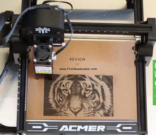 Acmer S1 6W laser engraver on a wooden workbench, engraving a tiger head