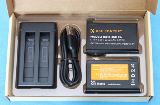 Unboxing of the K&F Concept X4 battery charger combo with charger and two camera batteries displayed in the original box.