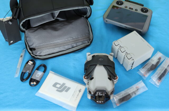 DJI Mini 4 Pro Fly More Combo box opened, showing the drone, RC 2 remote controller, extra batteries, and included accessories