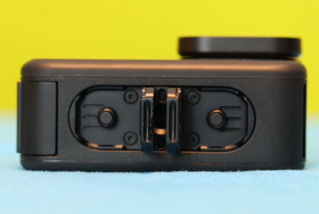 Bottom view of GoPro Hero 13 Black showing the built-in tripod mount and magnetic foldable mounting fingers.
