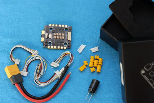 Unboxing the MEPS AeroCore 45A ESC showing the electronic speed controller, wiring, and packaging on a table.