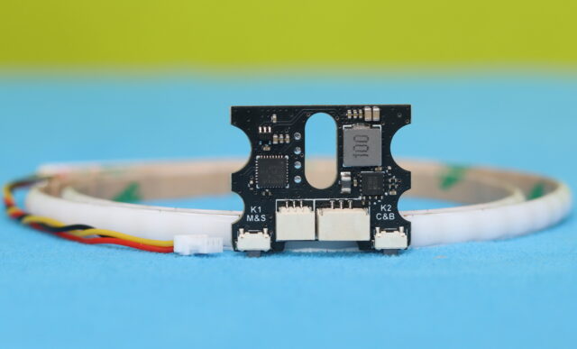 NightFire RGB LED strip connected to its controller, displaying multiple color lighting effects.