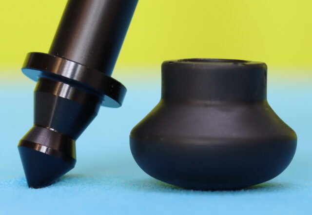 Close-up of the K&F CONCEPT 63-Inch Tripod foot showing the metal spike exposed and the removable rubber cap placed beside it.