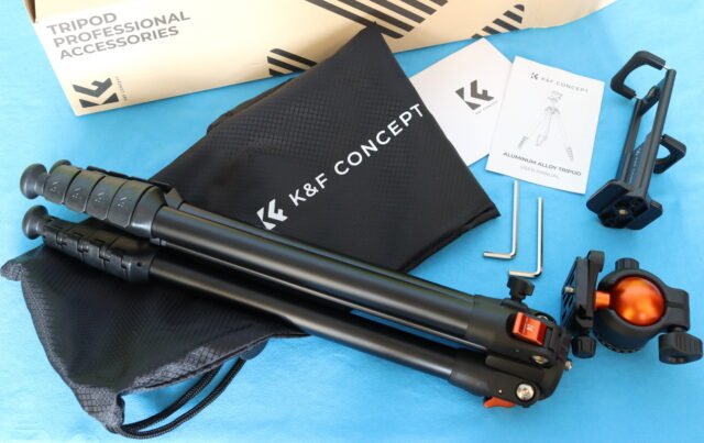 Unboxing the K&F CONCEPT 63-Inch Tripod with aluminum legs, ball head, and carry bag laid out on a table.