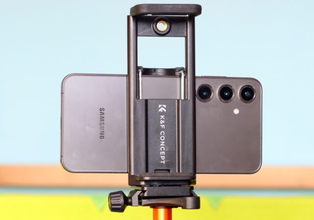 K&F CONCEPT 63-Inch Tripod 2-in-1 phone and tablet holder mounted on the tripod, showing the adjustable clamp mechanism.