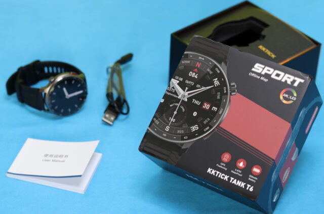 Unboxing the KKTICK Tank T6 rugged smartwatch showing the watch, charging cable, and packaging contents on a table.